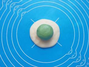 取一个油皮面团压扁，放上油酥面团包好。