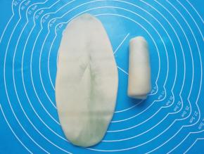 包好的油酥皮擀开，然后卷起来，收口朝下摆放，盖上保鲜膜备用。