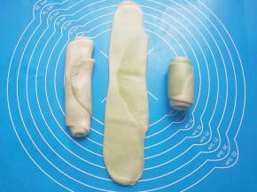 将卷好的油酥皮收口朝上轻压，擀开再次卷起，收口朝下摆放。