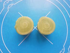 取一个松弛好的油酥皮卷，用锋利的刀从中间切开（切记不要放在揉面垫上切）