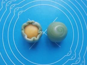 用虎口慢慢向上推挤收口，最后将收口朝下摆放，一个螺旋绿豆酥就完成了。