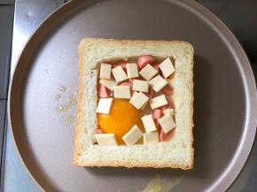 待鸡蛋稍微凝固，放入火腿肠和芝士，