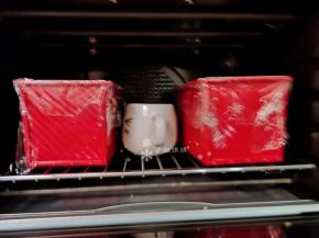 然后模具盖上保鲜膜放入烤箱，同时放一杯热水，关上烤箱门进行二次发酵。