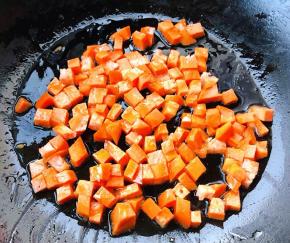 锅中倒入底油放入切好的胡萝卜丁翻炒均匀