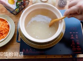 水烧开后放入淘洗后的爱心桃花小米，用勺子搅拌几下，避免小米沾锅底，同时电陶炉转中火继续煮。