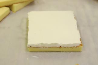 取一小片蛋糕片，正面抹上打发好的奶油。