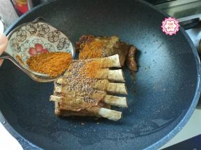 羊排煎好了，撒上我们准备好的孜然粉、孜然粒，还有辣椒粉，不喜欢吃辣的可以不放。