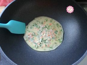 盖上盖子，加热30秒钟，打开盖子，看到小饼的周围翘起来了，把芹菜鸡蛋饼翻个面。