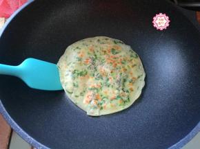 打开盖子，用铲子翻个面，小饼很有弹性，表面有了淡淡的金黄色就算烙好了。如果小饼烙熟的程度不够，会粘软，用铲子铲出来会断，会散掉。那就多翻几个面，时间加长一点儿，其他的面糊也都依次做好。