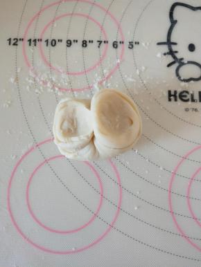 13、用大拇指和食指将面卷两端掐起来。