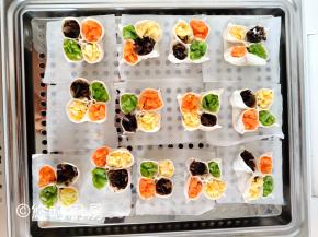 做好的四喜饺子摆放在蒸笼上，可以用油纸做垫纸，也可以直接在篦子上刷油，这个随意哈。