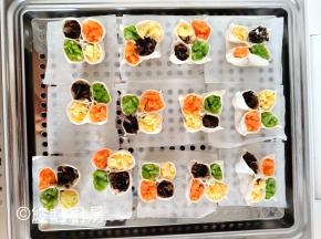 做好的四喜饺子摆放在蒸笼上，可以用油纸做垫纸，也可以直接在篦子上刷油，这个随意哈。