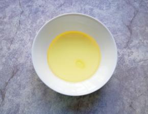 将牛奶和玉米油倒入小碗里。