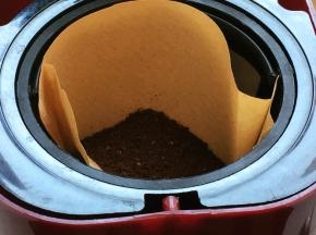 将研磨好的咖啡粉倒入滴漏咖啡机漏斗内，记得，一定要加滤纸。