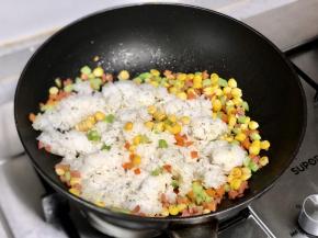 接着倒入米饭翻炒均匀。