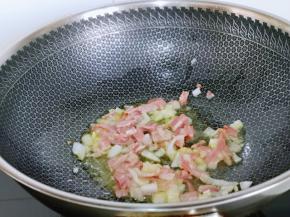 起油锅，加入洋葱煸炒出香味，再加入培根煸炒。