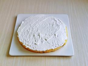 蛋糕体切成三片，取一片蛋糕放在蛋糕托上，抹上一层打发的奶油。