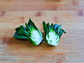 再把菜心从中间切开。