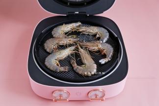 准备好大宇旋转烤盘，刷上一层薄油，把虾放入烤盘里，旋转到210度，盖上盖子，我用的是大宇旋转烤盘，烤8分钟左右。