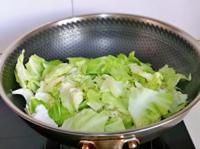 加入淋干水分的包菜，快速翻炒，将包菜炒软。