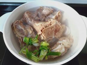 焯水后的骨头清洗干净，重新加入清水葱结，加清水盖过骨头开大火炖。