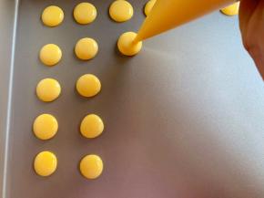 剪个小孔，挤入不粘烤盘中，注意溶豆的空隙，避免粘连