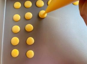 剪个小孔，挤入不粘烤盘中，注意溶豆的空隙，避免粘连