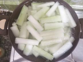 清水泡过的冬瓜条捞出，入锅，加水没过瓜条，煮开五分钟捞出