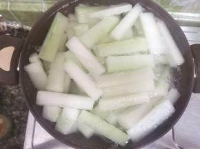 清水泡过的冬瓜条捞出，入锅，加水没过瓜条，煮开五分钟捞出