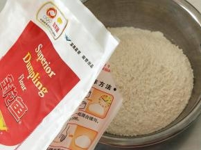 金龙鱼饺子专用麦芯粉200克倒入不锈钢盆里，然后加入盐和水搅拌成絮状