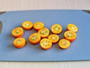 将泡好的金桔一切二。