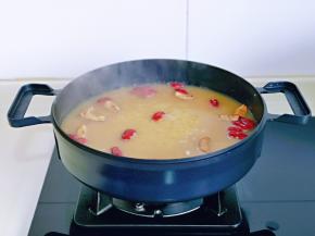 将红枣加入小米粥中，继续小火煮。