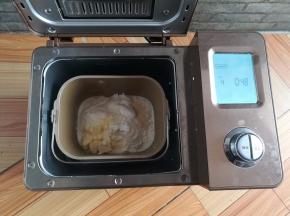 鸡蛋去壳，黄油切小块，把除坚果外所有的食材放入面包桶里，启动发面程序（和面28分钟+发酵20分钟）