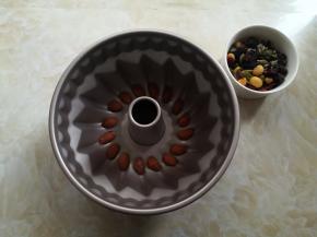 面包机和面的时候，把坚果中的大杏仁挑出来放入模具底部。