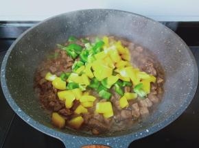 待牛肉粒熟透放双椒到锅里。