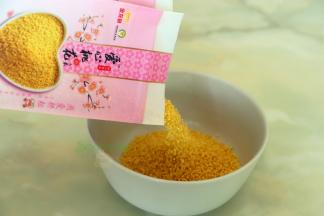 小米倒入碗里用清水清洗干净，挑选小米技巧，金龙鱼爱心桃花小米：外观粒大饱满，色泽金黄；口感味醇清香，熬粥米油 厚，米香浓郁，属于优质的小米。还具有安心养神，美容养颜的功效哦。