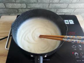 把小奶锅放到火源上，开中小火加热，用筷子不停的搅拌，防止糊底，一直搅拌到牛奶和玉米淀粉变成浓稠的糕状