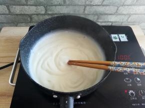 把小奶锅放到火源上，开中小火加热，用筷子不停的搅拌，防止糊底，一直搅拌到牛奶和玉米淀粉变成浓稠的糕状
