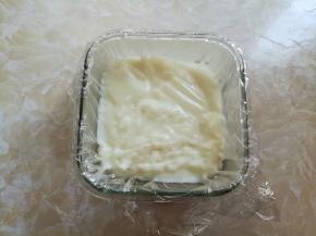 玻璃碗里事先垫一层耐高温的保鲜膜，把煮好的牛奶糕倒进玻璃碗里，室温下放到凝固