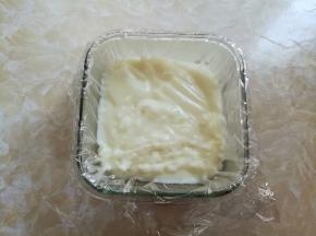 玻璃碗里事先垫一层耐高温的保鲜膜，把煮好的牛奶糕倒进玻璃碗里，室温下放到凝固
