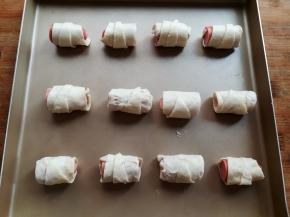 手抓饼香肠卷好后，放到不粘的烤盘里，间隔出一定的位置，