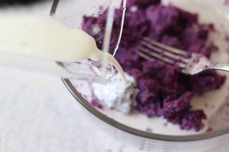 紫薯用叉子，压成紫薯泥，奶粉冲成奶液倒入到紫薯泥中，继续用叉子压成泥。