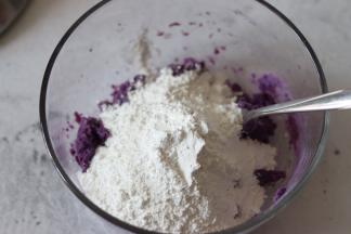 放入粘米粉和糯米粉的混合物，用叉子和紫薯泥混合，压拌的方法，慢慢的粉类和紫薯泥混合成有小块的散粒状。