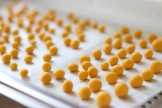 之后，取出一部分，放到案板上，搓成长条，切成小块，之后搓圆，南瓜圆子就制作完成了。