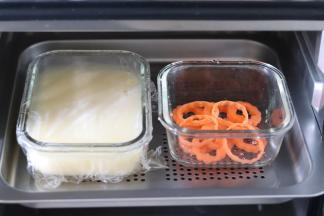 之后倒入到容器中，用保鲜膜包起来，和胡萝卜片一起放到蒸箱中。