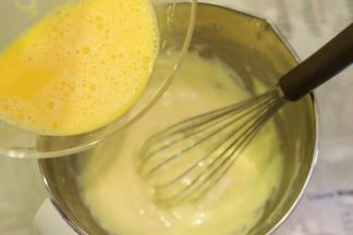 先将一半的全蛋液倒入奶酪糊内，搅拌均匀。