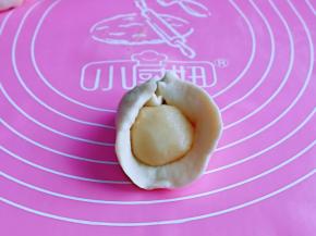 取一块油皮，用掌心压扁，在放上油酥，虎口手法包起来，收口朝下捏紧。