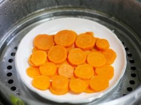 胡萝卜去皮切片上锅蒸熟。