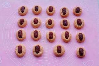 每个小剂子搓长一点，弄一个小坑放上枣片，按紧。