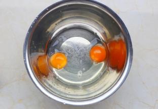 鸡蛋磕入盆中。
